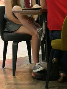Teen Sitting with Crossed Legs and Pulling her Skirt Up - Cafe Creepshot