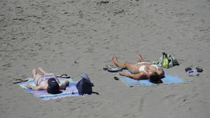 Sexy beach girl laying out in white bikini with nice body