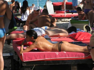Topless cutie at the beach with a tight little ass in a thong