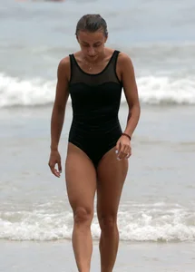 Skinny sexy lady on the beach in a black swimsuit