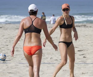 Hot girls playing beach volleyball in bikinis and shorts