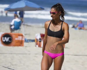 Hot girls playing beach volleyball in bikinis and shorts