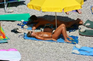 Nudist couple on the beach, girl has amazing tits and nice ass in a thong