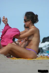 2 topless girls at the beach in thongs