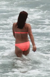 Thick girl in orange bikini playing on the beach