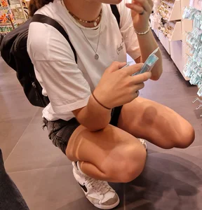 Candid Girl in Shorts Squatting at the Store Creepshot