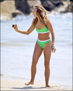 Super hot beach babe with a perfect body in a green thong bikini