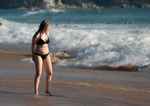 Cute bikini girl in the water in a black bikini
