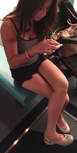 Skinny girl in shorts and flats sitting with crossed legs in a public bus
