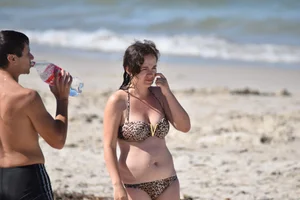 Brunette on the beach in a cheetah print bikini