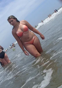 Thick beach girl with big boobs in a peach bikini