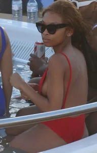 Sexy black girl in red swimsuit at the pool with side boob and a nice ass