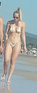 Smooth bodied and sexy blonde at the beach in a thong bikini