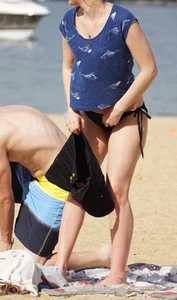 Sexy girl on the beach laying out and bending over in her bikini
