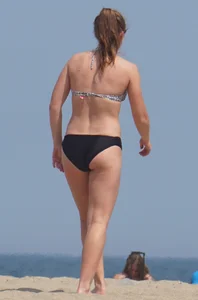 Sexy blonde girl on the beach in a bikini with nice legs, ass and stomach