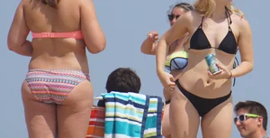 Two thick white girls in bikinis on the beach with big asses