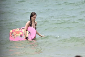 Skinny and sexy brunette on the beach in black and blue bikini