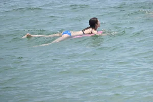Skinny and sexy brunette on the beach in black and blue bikini
