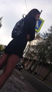 Amazing hot teen cutie wearing a short skirt and black pantyhose with a backpack standing on the crosswalk creepshot