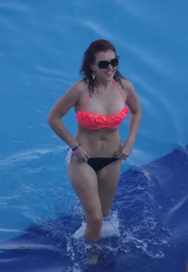 Sexy red haired girl in pink and black bikini at the pool
