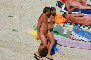 Nudist couple on the beach, girl has amazing tits and nice ass in a thong