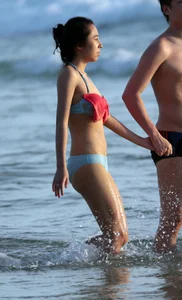 Cute Asian in bikini on the beach with her boyfriend