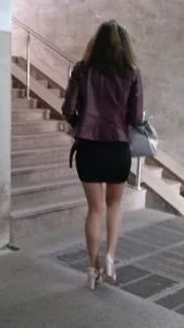 Hot girl walking up the stairs, wearing a skirt, pantyhose and high-heeled shoes