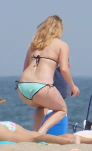 Cute girls in light blue and purple bikinis on the beach
