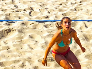 Hot girls playing beach volleyball in bikinis and shorts