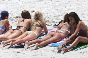 Skinny (latino) brunett in purple thong on the beach