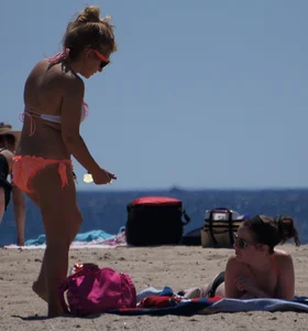 Thick blonde girl in an orange bikini on the beach