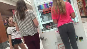Little blonde teen in grey leggings at the mall with her friends