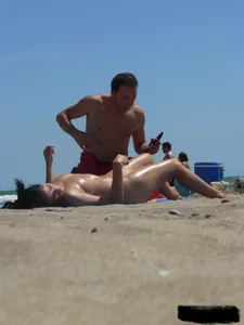 Purple thong topless lady on the beach gets oiled up by her husband