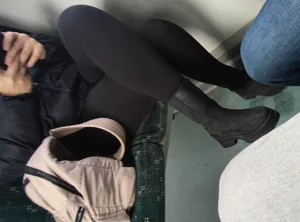 Candid girl in boots and tigth pants sitting in public transport with crossed legs