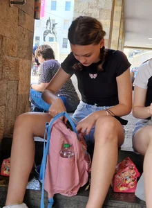 A Cute Teen Girl in Shorts Sitting on the Steps Street Photos