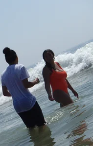 Beach girl with big boobs in an orange swimsuit