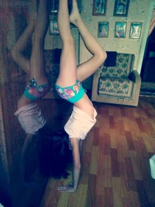 Skinny Girl in Shorts and a Top Doing a Handstand With Bare Feet Home Photo
