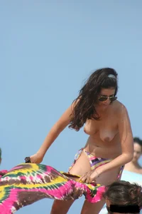 2 topless girls at the beach in thongs
