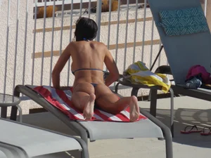 Hot milf sunbathing in a thong by pool and swimming