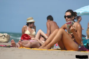 2 topless girls at the beach in thongs
