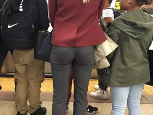 Blonde in tight dress pants waits for the train