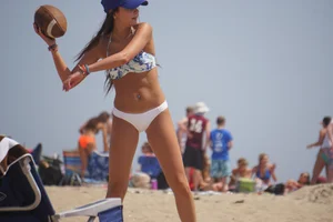 Beach football sexy brunette in white bikini