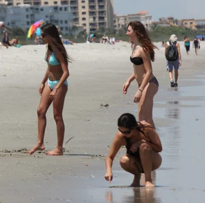 Brunette and redhead on the beach in bikinis looking sexy