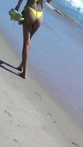 Beach babe with a nice ass and big tits in yellow thong bikini