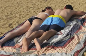 Sexy girl on the beach laying out and bending over in her bikini