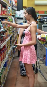 Teen in awesome legs wearing a short dress and slippers at the supermarket