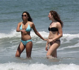 Brunette and redhead on the beach in bikinis looking sexy