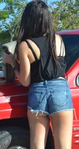 Brunette in short denim shorts showing a little cheek