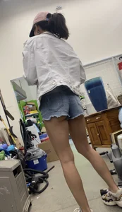 Tight bum hanging out of jean shorts in thrift shop