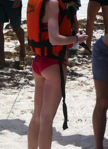 Tall sexy skinny brunette on the beach in a red bikini